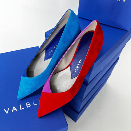 V A L B L V pointed toe flat ballerina shoes in contrasting blue and red suede on top of blue designer shoe boxes.